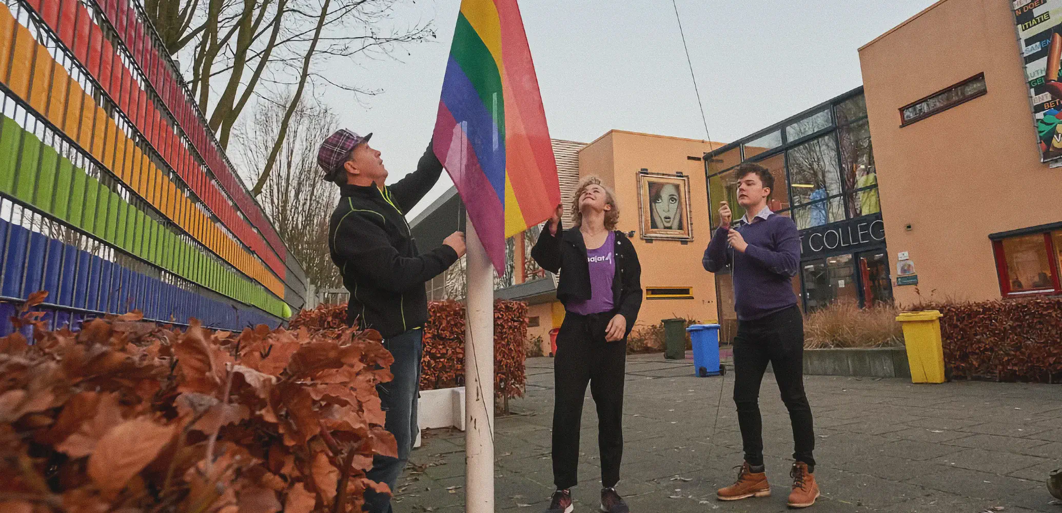 Ter ere van Coming Out-dag wordt de regenboogvlag gehesen op een schoolplein.